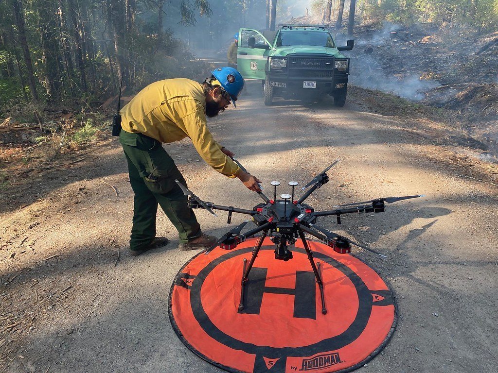 Fire crew member preparing a hexacopter on a landing pad